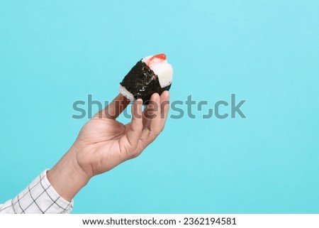 The Asian man hand holding the japanese food on the green background.
