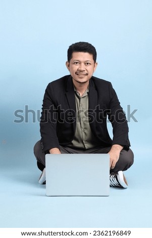 The adult business Asian man in smart casual clothes sitting on the floor on the green background background.