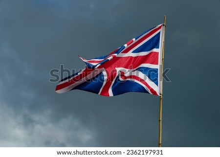 The Union Jack flag of United Kingdom English Britain flag flying in the wind on bamboo pole.
