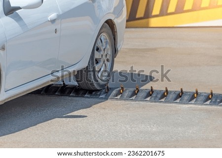 Spikes barrier are frequently used to enforce a directional flow in a single traffic lane. Car departing from the parking lot Royalty-Free Stock Photo #2362201675