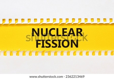 Nuclear fission symbol. Concept words Nuclear fission on beautiful yellow paper. Beautiful white table white background. Business science nuclear fission concept. Copy space.