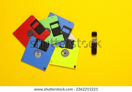New and old technologies. Retro floppy disk and modern usb flash drive on a yellow background. Top view