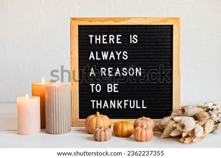 Felt letter board and text there is always a reason to be thankful. Autumn table decoration. Interior decor for thanksgiving and fall holidays with handmade pumpkins, candles