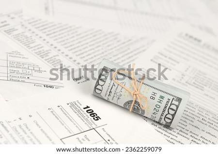 1065 U.S. Return of Parentship Income form with roll of american dollar banknotes close up. Concept of tax period in United States Royalty-Free Stock Photo #2362259079