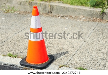 orange construction cone on a road, symbolizing safety, caution, and ongoing work at a construction site