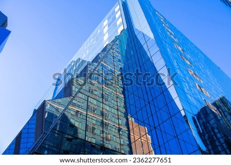 New York City, tall building picture, taken on Manhattan towards a blue building in a blue sky.