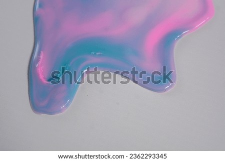 Colorful leaking paint liquid spills from close range