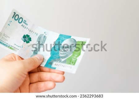 Hand holds a Colombian bill of one hundred thousand pesos, good economy, financial stability, horizontal photo
