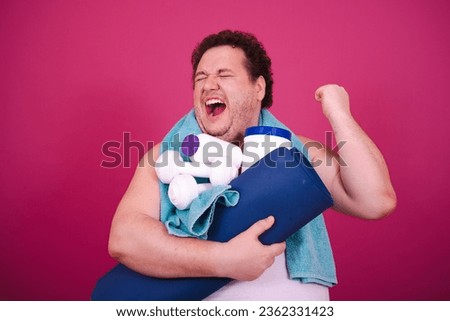 Diet, sport and healthy lifestyle. Funny fat man doing fitness and posing on a pink background.