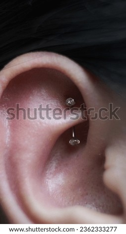 Rook piercing on model ear Royalty-Free Stock Photo #2362333277