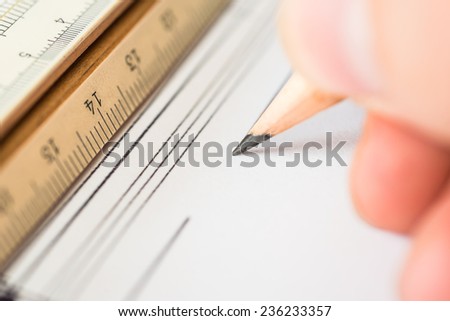 Hand holds the pencil to create a drawing. Angle view close-up