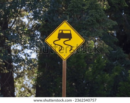 A slippery road warning sign posted in areas where a slippery condition might exist.