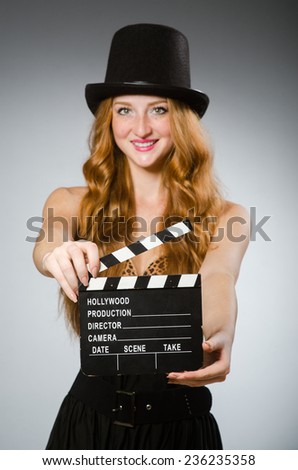 Woman with movie board wearing hat