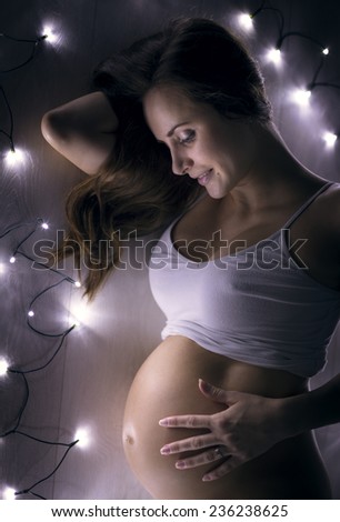 beautiful pregnant girl with Christmas flashing lights, beautiful portrait image