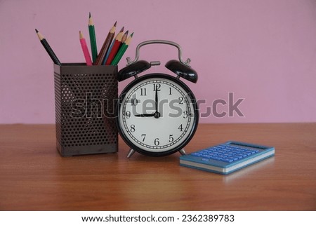 alarm clock with pencils case on the table