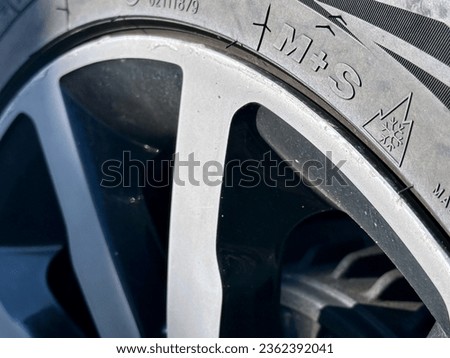 All-Season Tire Marked with M+S Logo: Rolling at the Four Seasons from Winter in Mountains to Summer Royalty-Free Stock Photo #2362392041