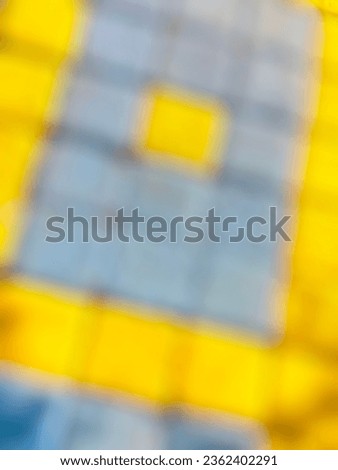 photo of an out-of-focus yellow and blue square floor
