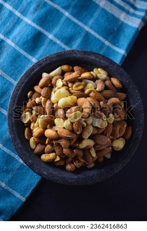 Peanuts photo. Nuts in the container. Almonds. Peanuts. Cashew nut. Macadamia nuts. Green cloth
