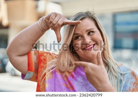 Young woman smiling confident doing photo gesture with hands at street
