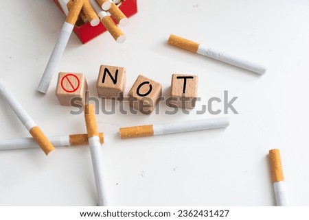 Studio shot of cigarette pack with wooden alphabet cubes isolated on white, stop smoking concept