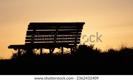 Silhouette of a bench dyed by sunset
