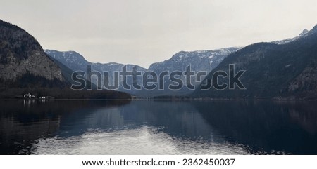 a photography of a lake with mountains in the background, valley with mountains and a body of water with a boat in it.