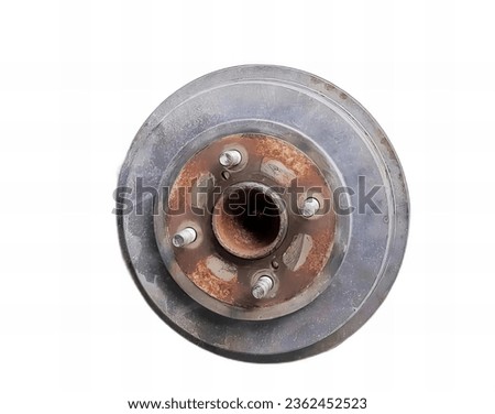 a photography of a metal object with a hole in the middle, disc brake of a car with rusted paint and bolts.