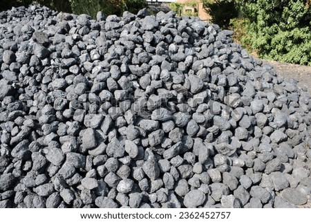 Large pile of coal rocks outdoors taken on a sunny day Royalty-Free Stock Photo #2362452757