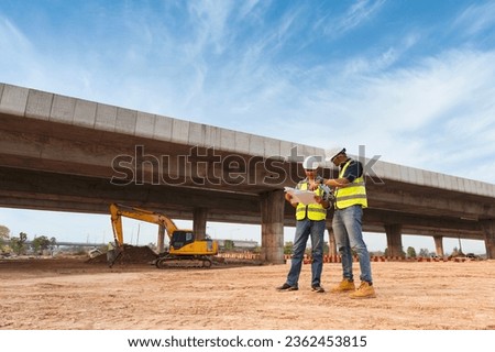 The chief civil engineer is introducing inspection of a road or expressway construction project under the road to an intern. At the expressway construction site Royalty-Free Stock Photo #2362453815