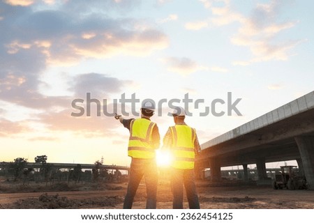 The chief civil engineer is introducing inspection of a road or expressway construction project under the road to an intern. At the expressway construction site Royalty-Free Stock Photo #2362454125