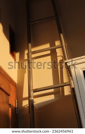 This is a portrait of an object in the corner of the room illuminated by the morning sunlight known as the golden hour, along with its shadow.