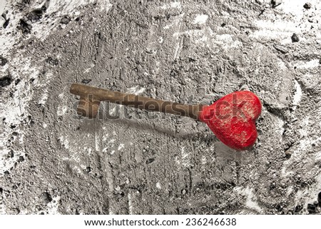 Old rusty iron key on grey ash background