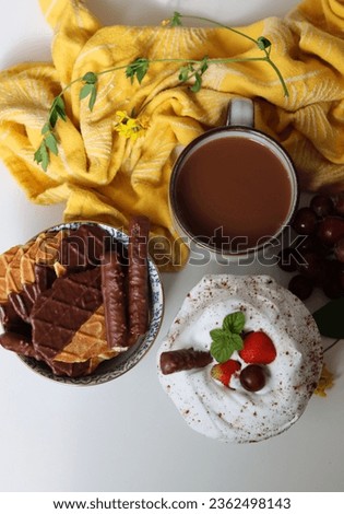 Cup of hot chocolate with whipped cream, wafers and strawberries on white background with copy space. Sweet food concept. 