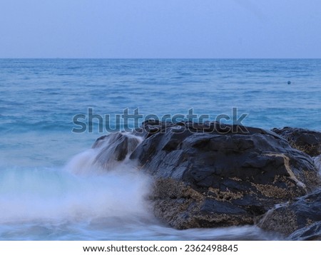 Slow shutter speed image of waves breaking over the rock