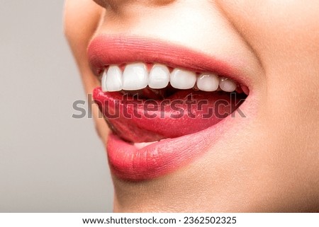 Closeup shot of woman's toothy smile. Perfect healthy teeth smile woman. Dental health concept. Teeth whitening procedure. Dental care. Woman tongue seductively licking lips. Beautiful chubby lips. Royalty-Free Stock Photo #2362502325