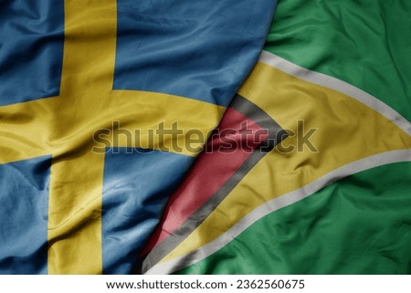 big waving national colorful flag of sweden and national flag of guyana . macro