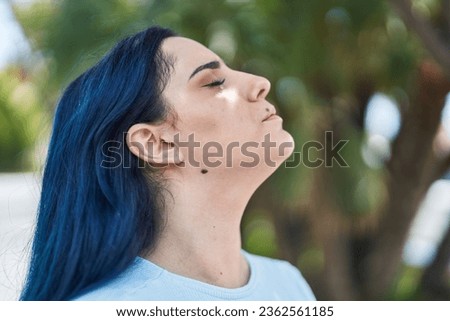 Young caucasian woman breathing with closed eyes at park