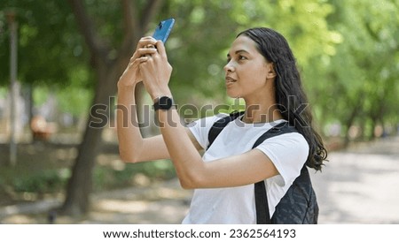 African american woman tourist make photo by smartphone wearing backpack at park