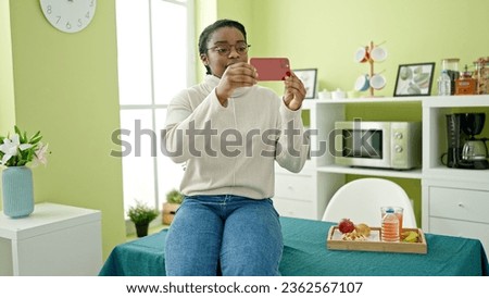 African american woman taking picture at dinning room