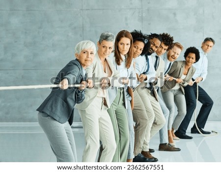 Portrait of a young  businesspeople pulling a rope in the office  Royalty-Free Stock Photo #2362567551