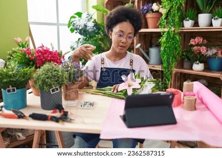 African american woman florist having video call make bouquet of flowers at street