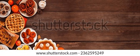 Autumn desserts corner border. Table scene with assorted traditional fall sweet treats. Top view over a rustic wood banner background. Copy space. Royalty-Free Stock Photo #2362595249