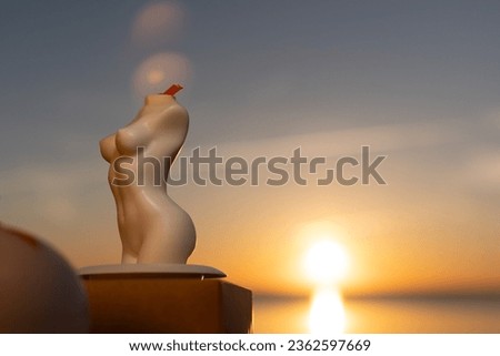 Candles female silhouette against sunset background