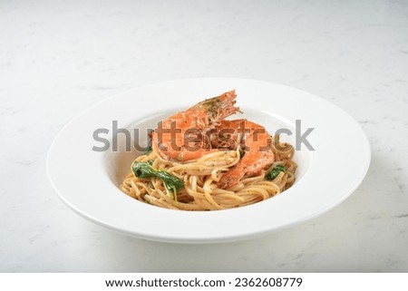 seafood pasta with big tiger prawn, scallop shell clam and muscle in olive oil salted egg yolk paste sauce in plate on white marble table western spaghetti cuisine halal food hotel luxury cafe  menu Royalty-Free Stock Photo #2362608779