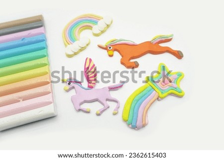 modeling clay unicorn pastel colors with a rainbow on a white background.