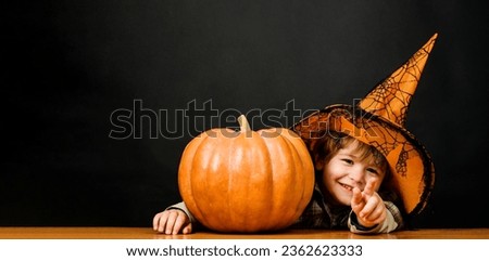 Smiling kid boy in witch hat with Halloween pumpkin. Preparation for Halloween holiday. Thanksgiving day cooking. Halloween child with jack-o-lantern pumpkin. Trick or treat. Halloween sale. Discount.