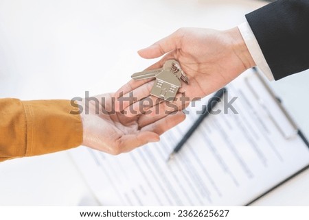 Top view agent giving a key to new owner or tenant, client after signed signature contract rental purchase, buyer apartment, home with landlord, realtor. Banker agreement mortgage loan. Property lease