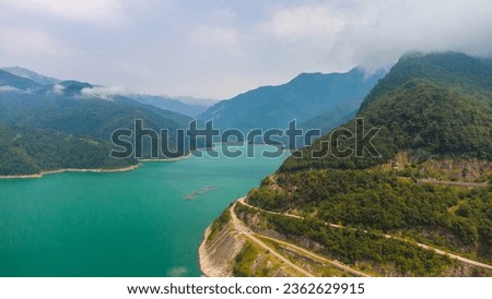 Mountain river Inguri with blue water. The Inguri river in the summer is from a height. The river in the mountains with turquoise water. Arial View of Svaneti, Georgia, summer natural landscape