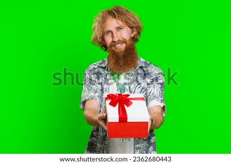 Positive smiling man presenting birthday gift box stretches out hands, offer wrapped present career bonus, celebrating party, promotion discount sale. Redhead guy isolated on chroma key background