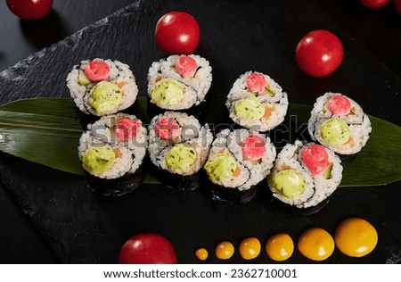Traditional Japanese food - sushi, rolls and sauce on a black background. Top view